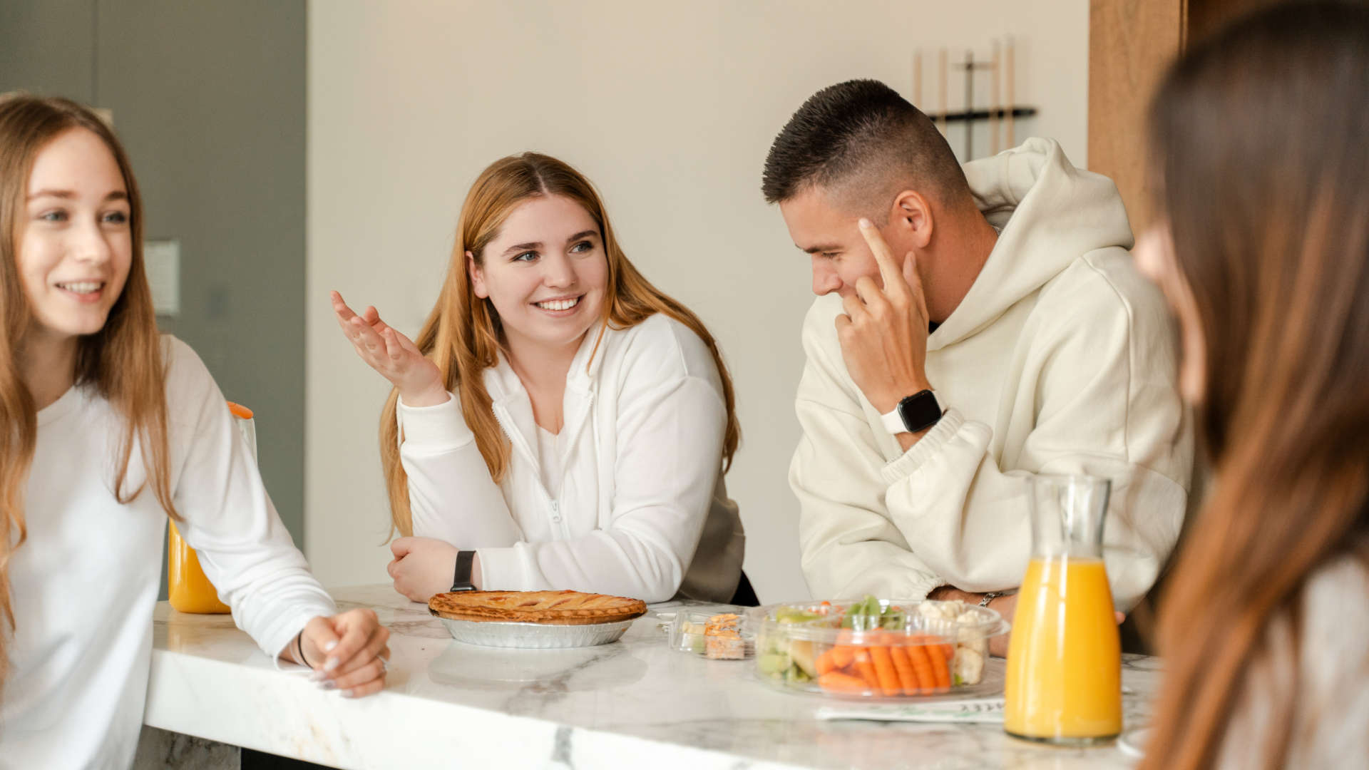 Gesprächssituation mit mehreren Personen an einem Tisch in einem Wohnraum