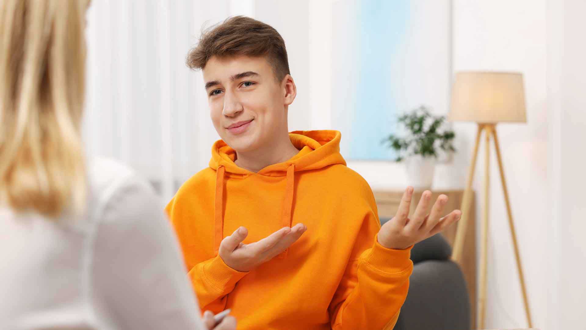 Ein Jugendlicher gestikuliert im Gespräch mit einer anderen Person.